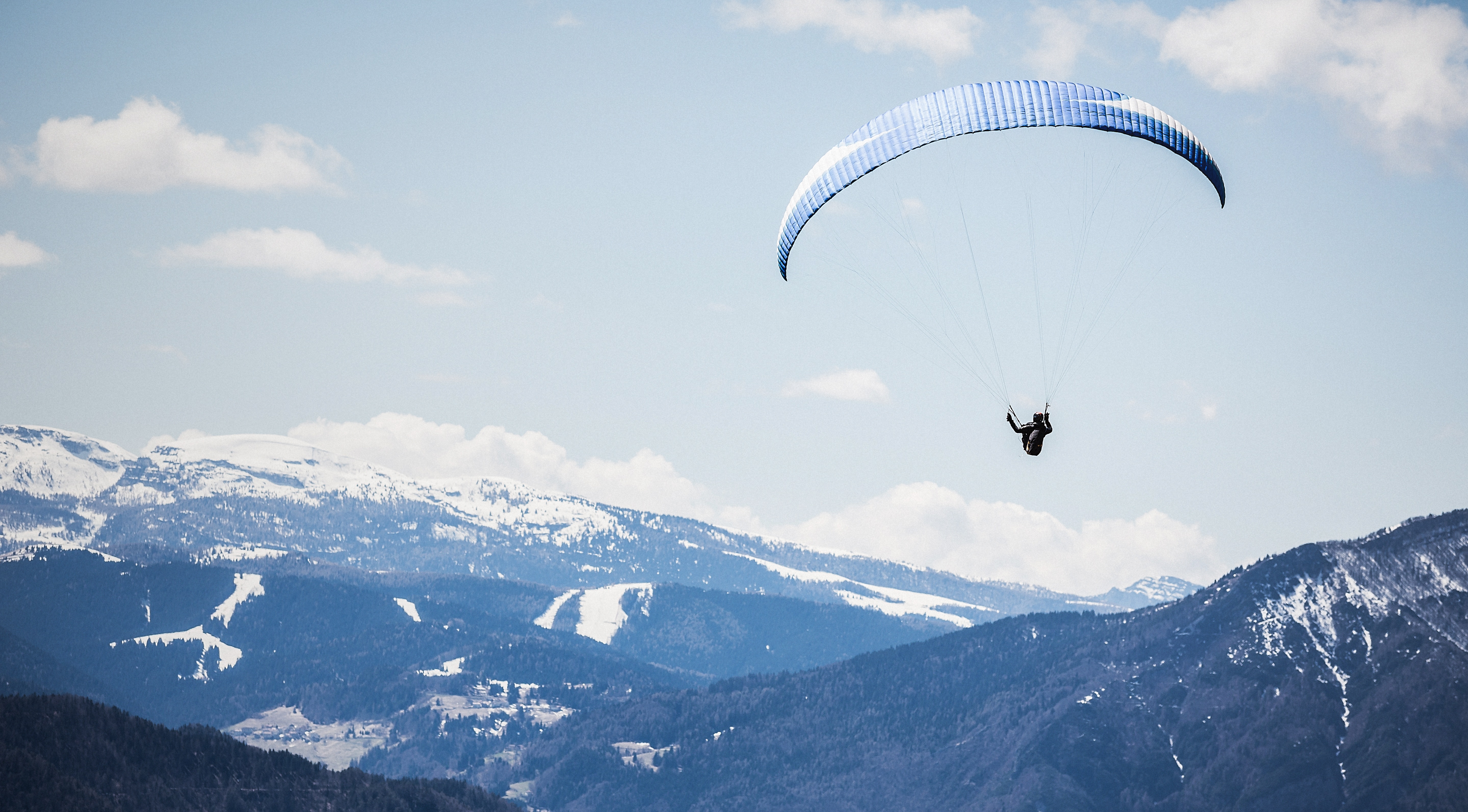 Parasailing in snowy mountainous alps