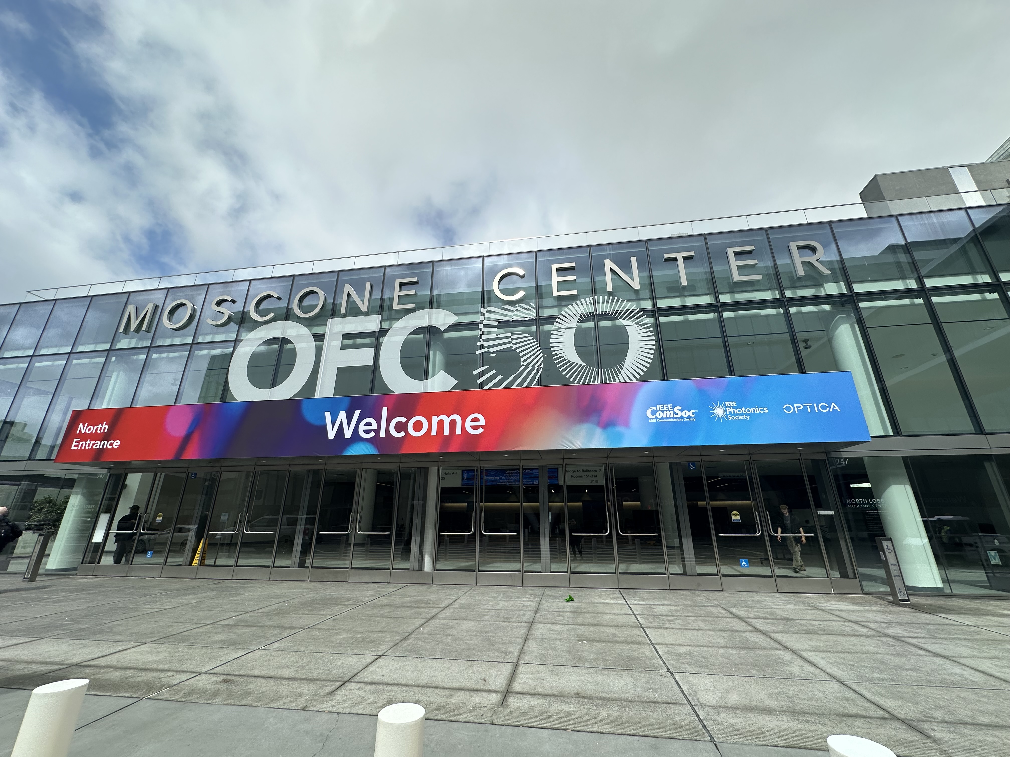 Exterior view of Moscone Center with OFC50 logo on the building.