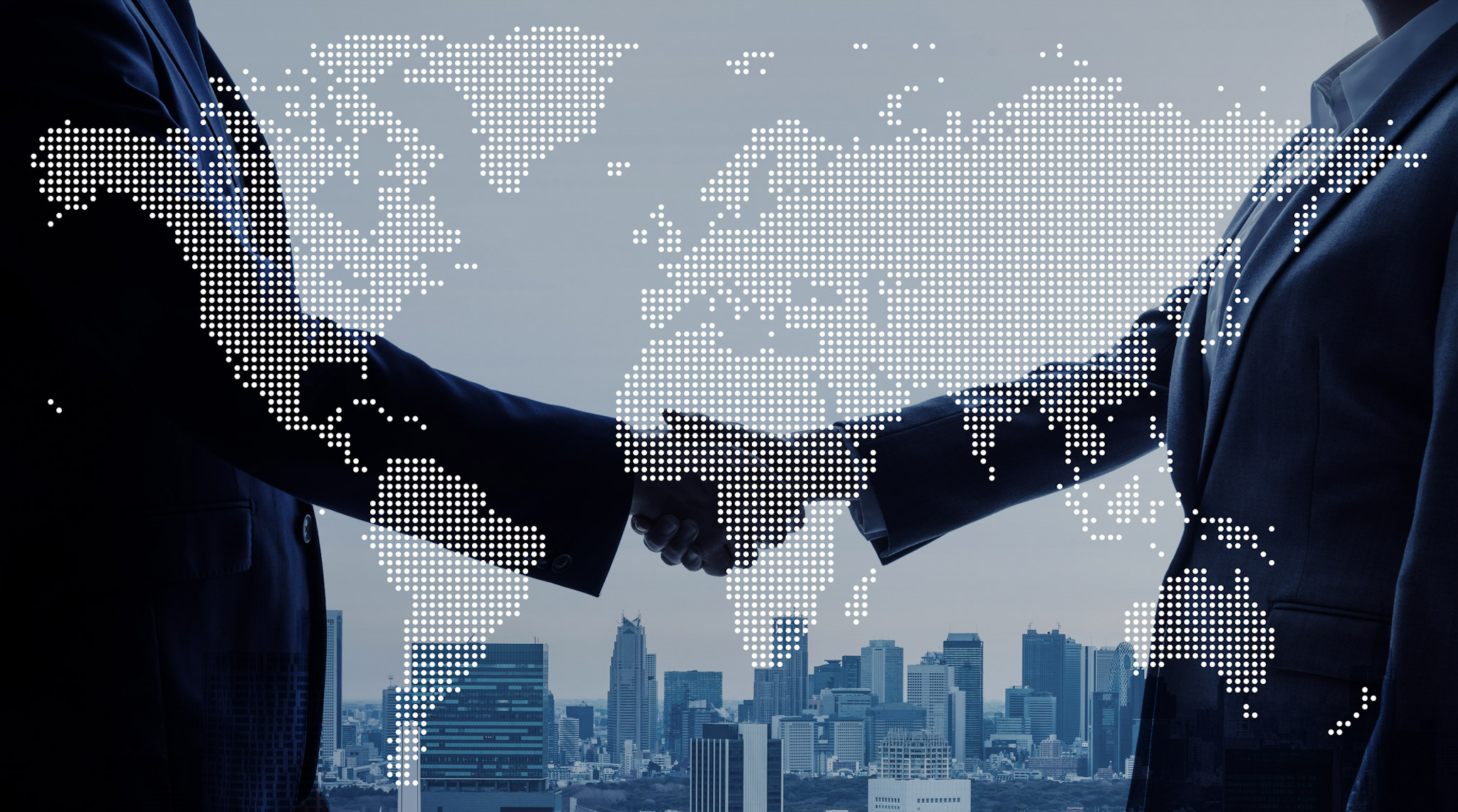 Two business professionals shaking hands in front of a city skyline, overlaid with a world map