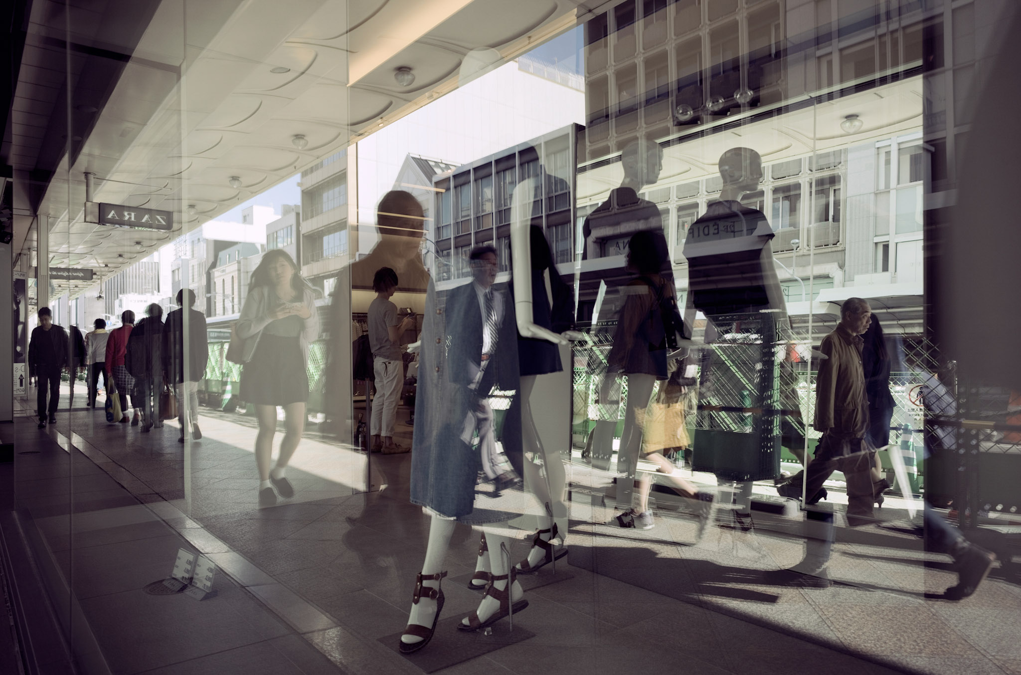 People walking by a sideway getting reflections