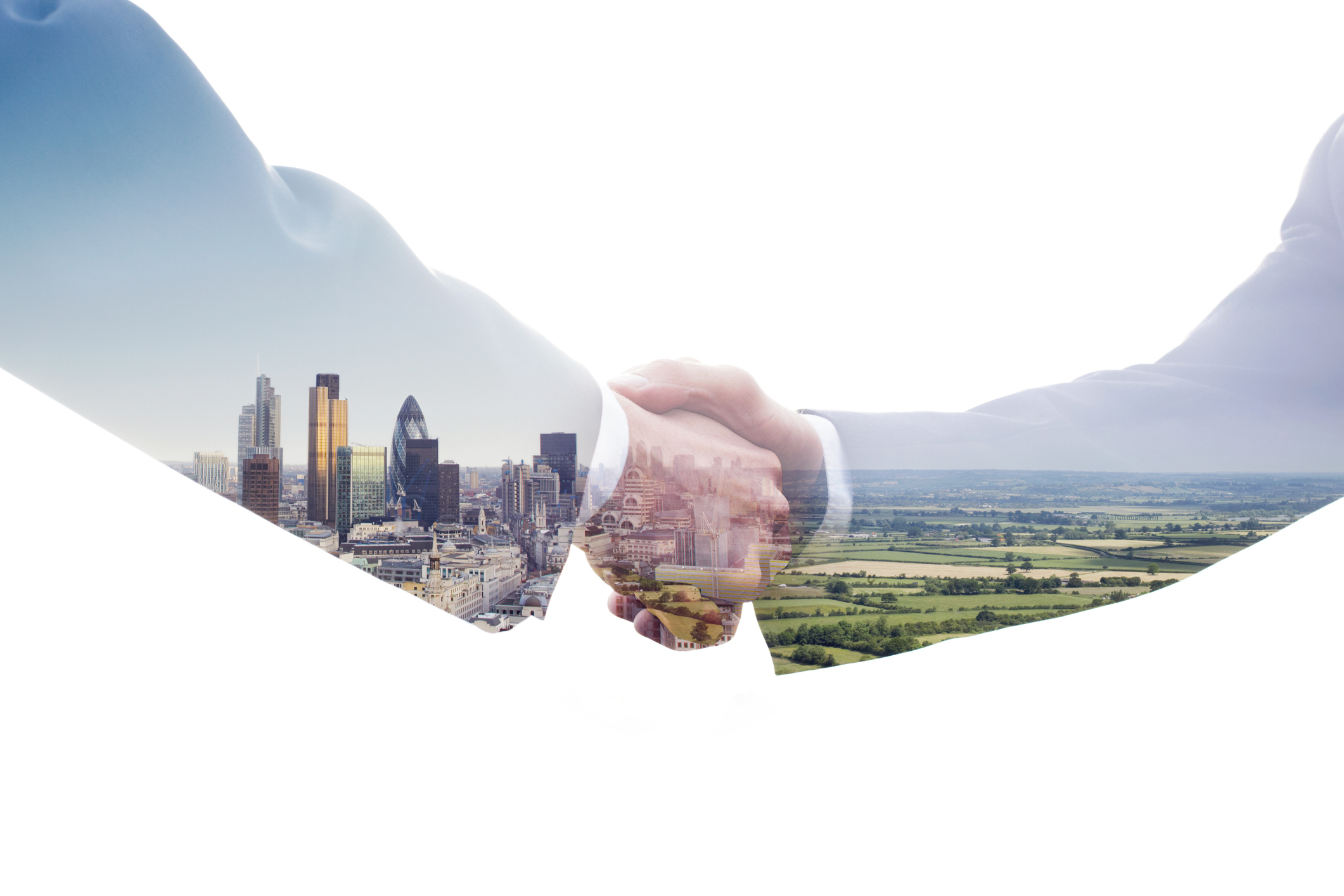 Two business professionals shaking hands with a double exposure of a modern city skyline and a rural landscape