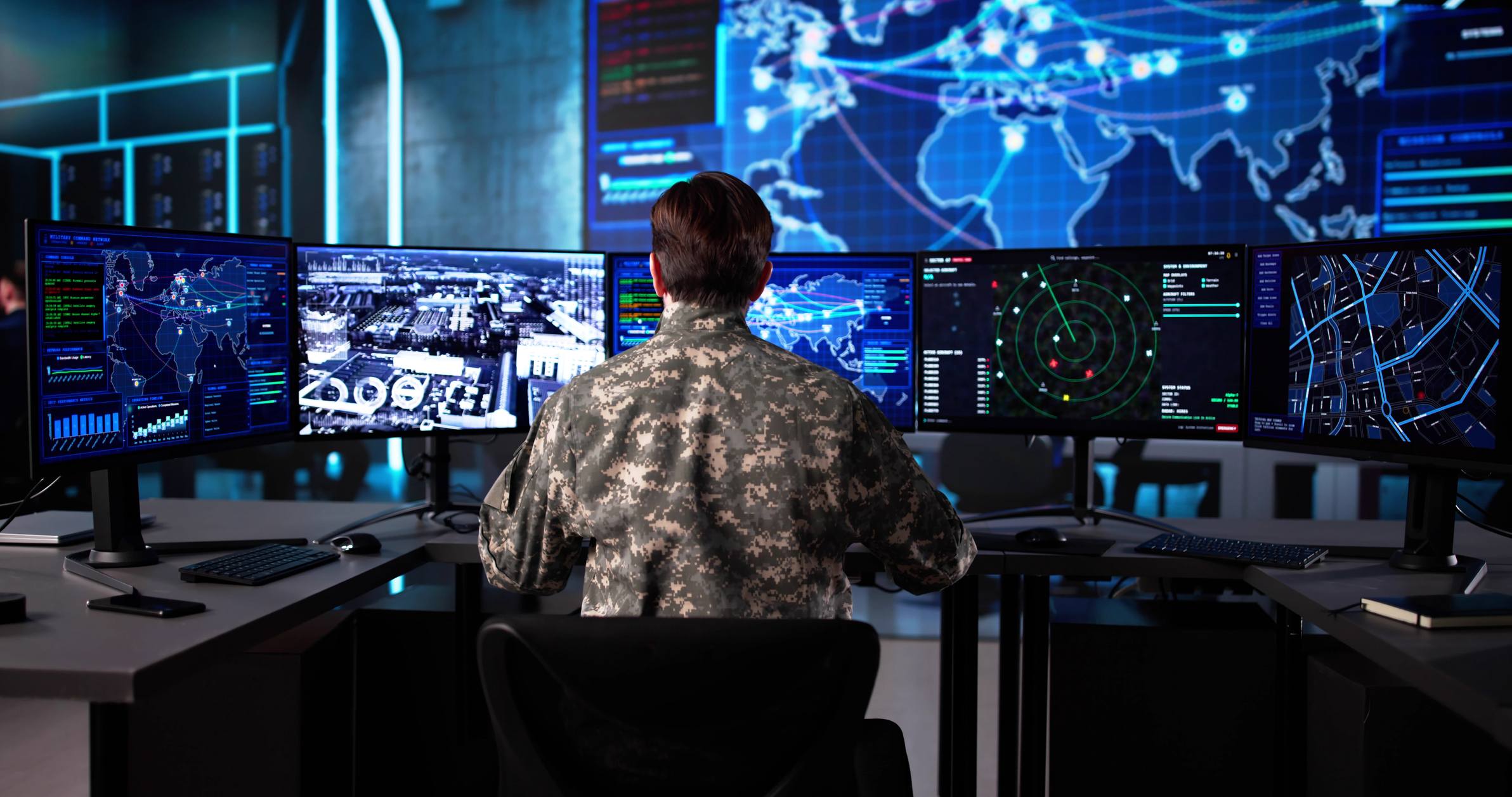 Military officer in camouflage uniform monitoring missile defense data across multiple screens in a dark command and control operations center