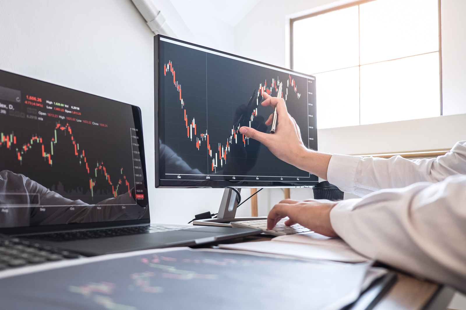 Stock exchange market concept, Business investor trading or stock brokers having a planning and analyzing with display screen and pointing on the data presented and deal on a stock exchange.