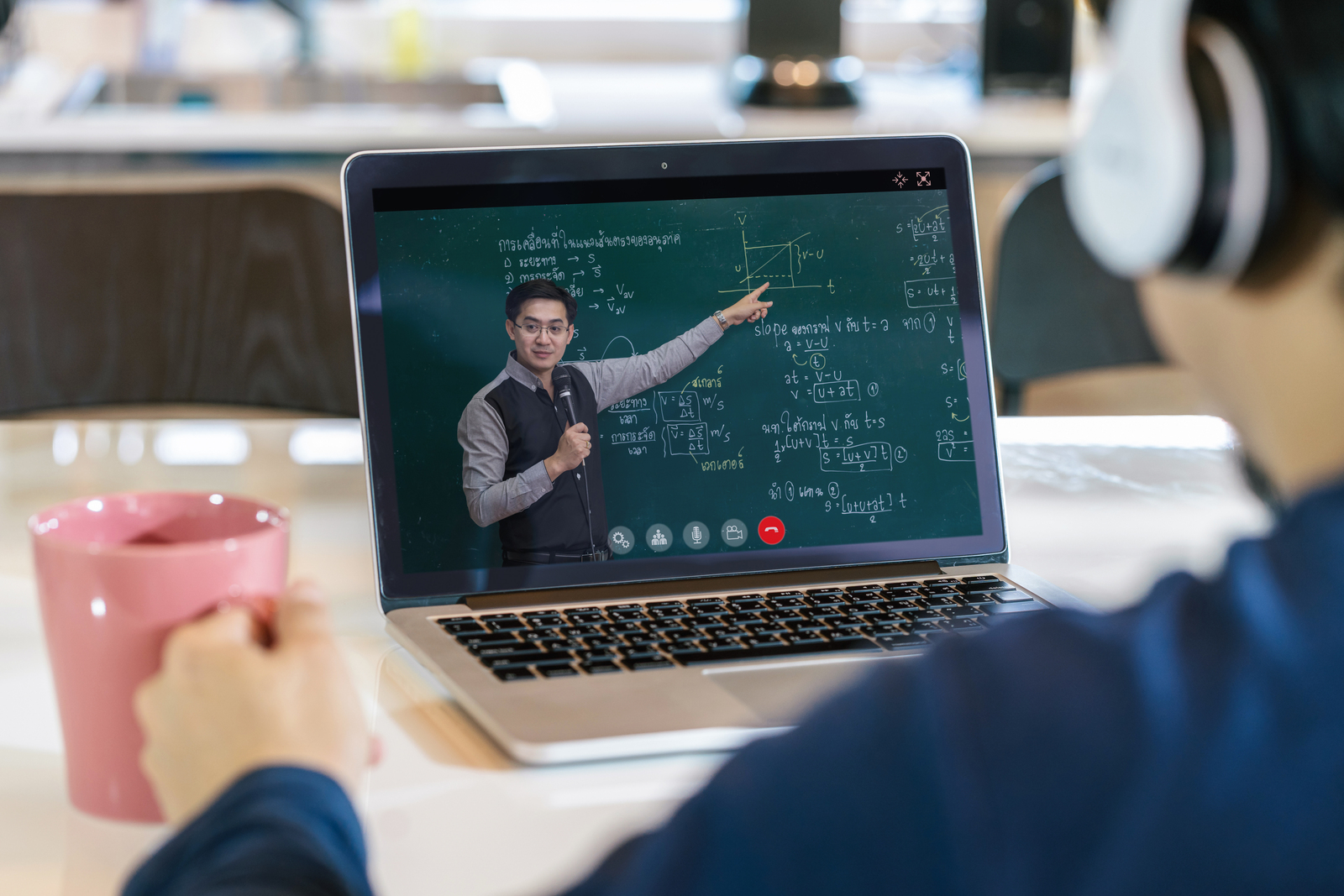 Rear View of Asian student learning with teacher on black board via video call conference