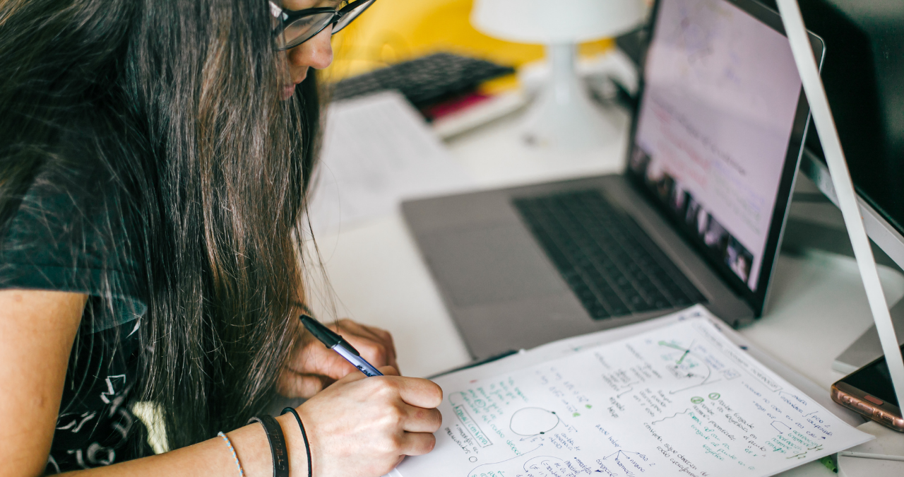 Female college studying next to a laptop