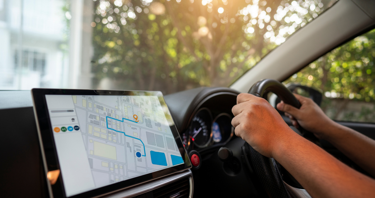 A person is driving a car using a connected navigation screen.